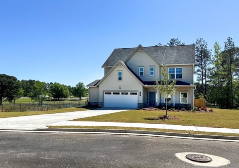 A two-story house with a garage and a driveway.